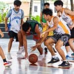 Programs 11 Youth basketball game on an outdoor court during daytime.