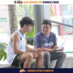 Programs 39 Young athletes sitting and talking outdoors at a sports event.