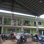 Programs 52 A church building with a covered outdoor area and parked motorcycles and cars in front.