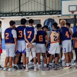 Programs 30 Youth basketball team huddling during a game in an indoor gymnasium.