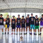 Programs 15 Youth basketball team standing in a row under a covered court.