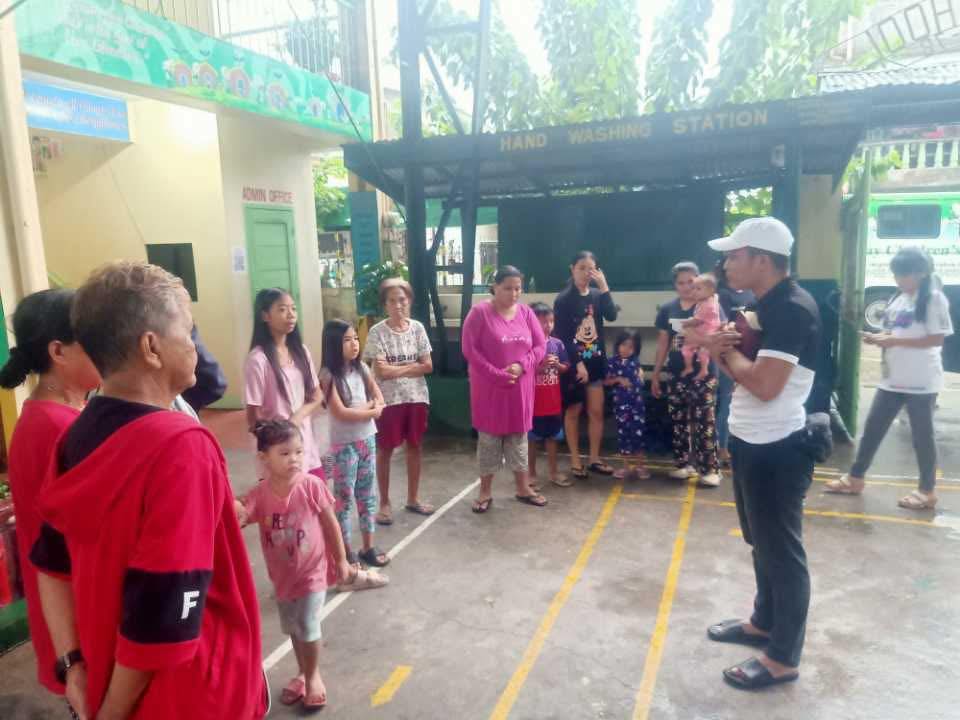 Pastor John Mark sharing the Word of God with families gathered at an evacuation center during a relief operation in July 2025.